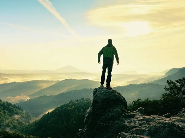 Wanderer steht auf Sandsteingipfel in felsigem Park und wacht über nebliges Morgental — Stockfoto