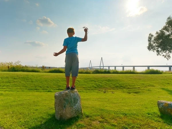 Um rapaz de t-shirt azul em offshore a olhar para a ponte de trânsito sobre a baía. A ponte de duas estradas com torres de corda alta — Fotografia de Stock