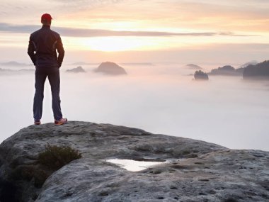 Yalnız kırmızı bere stand kumtaşı kaya kaya empires park ve sis içinde izlerken tepe üzerinde uzun yürüyüşe çıkan kimse