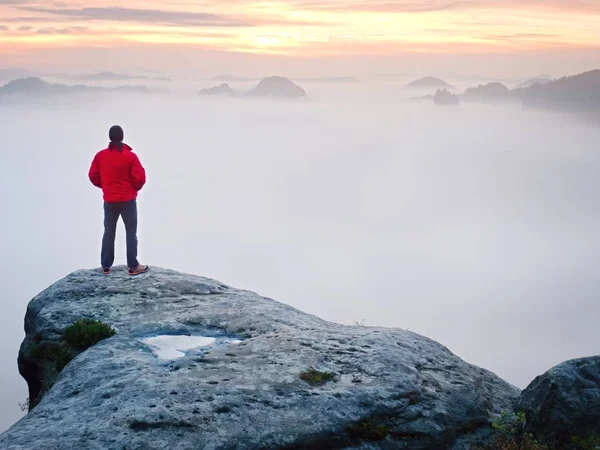 Οπίσθια όψη να ταξιδιώτη αυτοδύναμη στον γκρεμό με πόδια παρακάτω ομίχλη, ηλιοφάνεια σε συννεφιά — Φωτογραφία Αρχείου