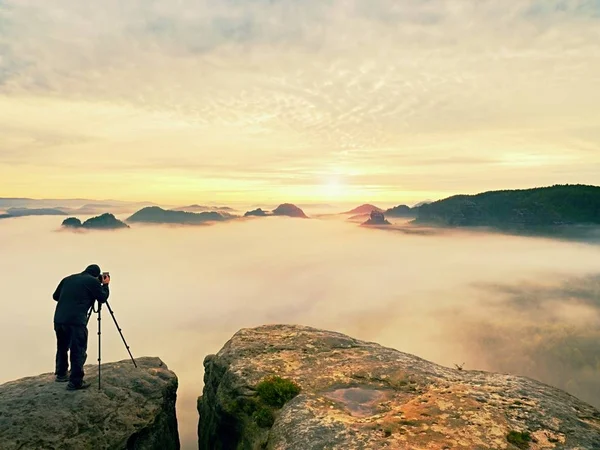 Silhouette de photographe au-dessus d'un nuage mer, montagnes brumeuses — Photo