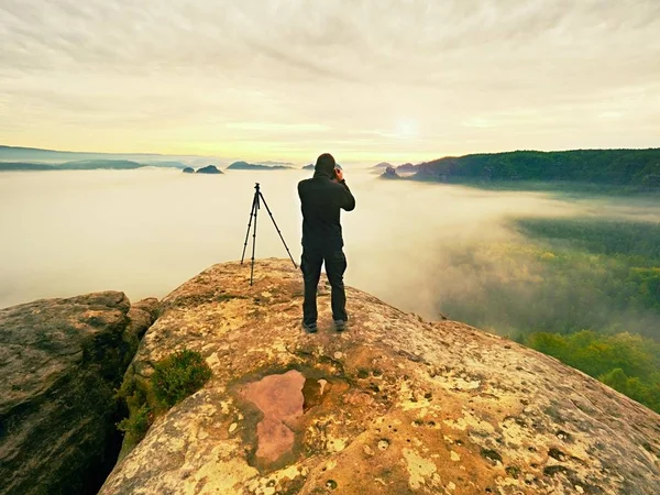 Fotógrafo enmarcando la imagen con el ojo en el visor. entusiasta de la foto disfrutar del trabajo, naturaleza caída — Foto de Stock