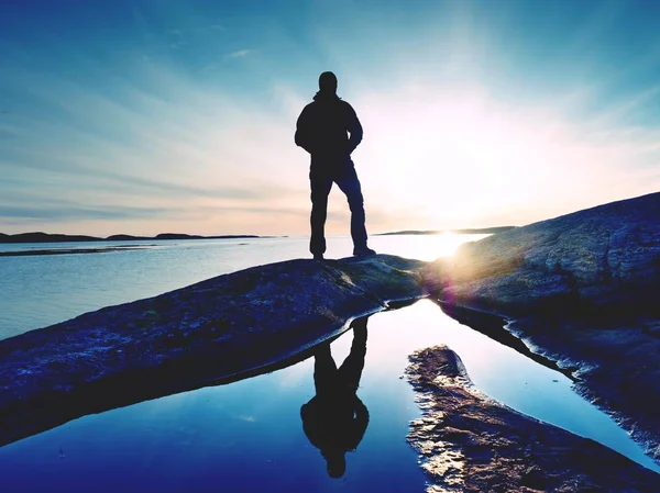 Silhouette homme sur la falaise au-dessus de la mer. Touriste autonome sur le rocher et regarder l'horizon de la mer — Photo