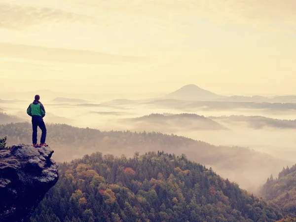 Man stay on rocky peak within daybreak and watch over misty landscape. — Stock Photo, Image