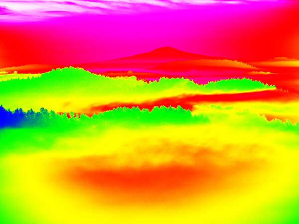 Thermography photo. Animal view. Spring landscape. Hills, forest and fog with chaned colors to ultraviolet.