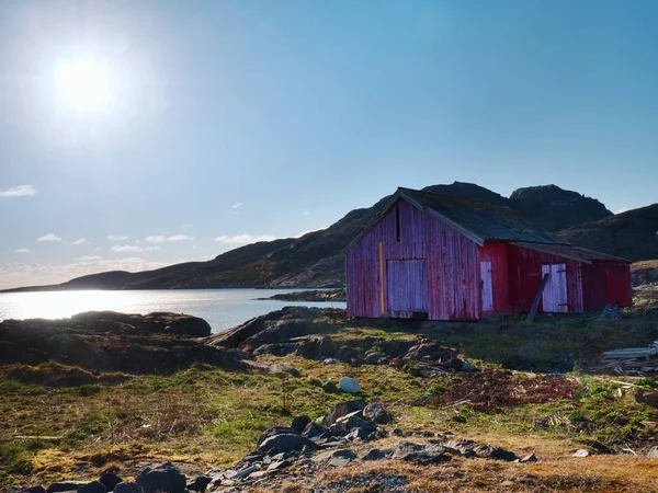 Casa de barco vermelho no cais, ilha rochosa, Noruega. Edifício branco vermelho tradicional no cais perto do mar — Fotografia de Stock