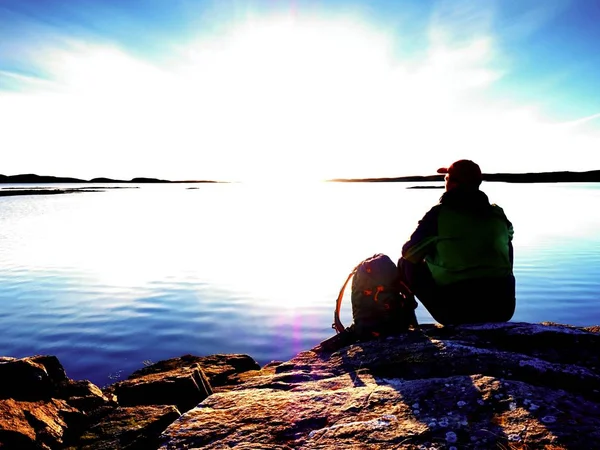 외로운 남자 등산객 해안과 석양을 즐기는에 혼자 앉아 있다. 바다 바위 절벽 위로 보기 — 스톡 사진