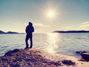  Etkin adam Denizi kayalık kıyıdan balık tutuyor. Balıkçı onay iterek yem