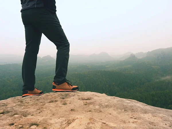 Pernas de caminhante em confortáveis botas de trekking na rocha. Homem pernas em calças leves ao ar livre, sapatos de couro — Fotografia de Stock