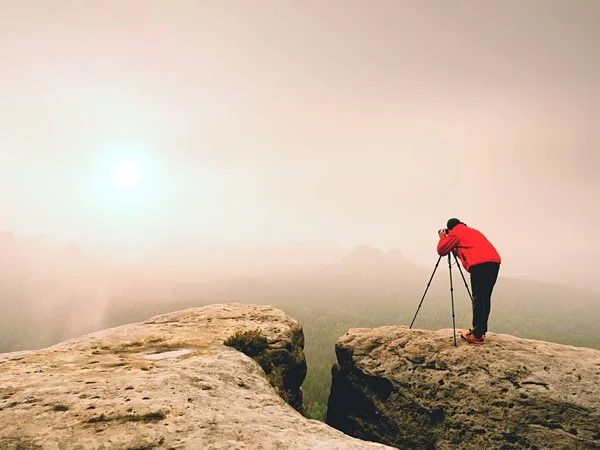 Photographr ψάχνει στο σκόπευτρο της περίπτερο ψηφιακής φωτογραφικής μηχανής dslr σε τρίποδο. Καλλιτέχνης φωτογραφίζει βουνό και θολό τοπίο — Φωτογραφία Αρχείου