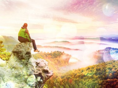 Soyut etkisi. Kumtaşı kaya ve renkli sis ve sis sabah Vadisi'nde izlerken tepe üzerinde turist sit.