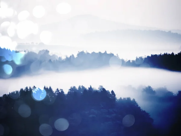 Effet abstrait. Lever de soleil d'automne en montagne dans l'inversion. Des sommets de collines se détachent du brouillard — Photo