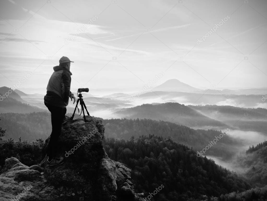Photographer looks into the landscape and listen the silence. Man prepare camera to takes photos 