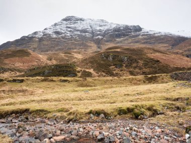 Dağ dere karla kaplı doruklarına içinde geçmiş. Alçak bulutlar ile karanlık gökyüzü. 