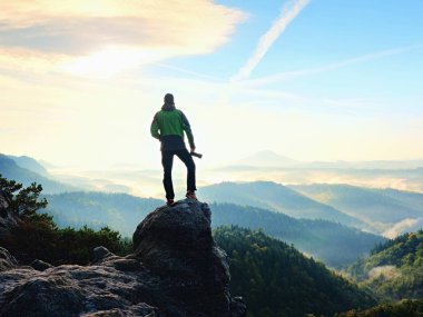 Cliff fotoğrafçı. Doğa fotoğrafçısı kaya tepe üzerinde ayna kamera ile fotoğraf çeker.