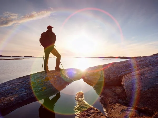 Belo pôr-do-sol de verão à beira-mar. Homem de pé com mochila no oceano contra o pôr do sol . — Fotografia de Stock