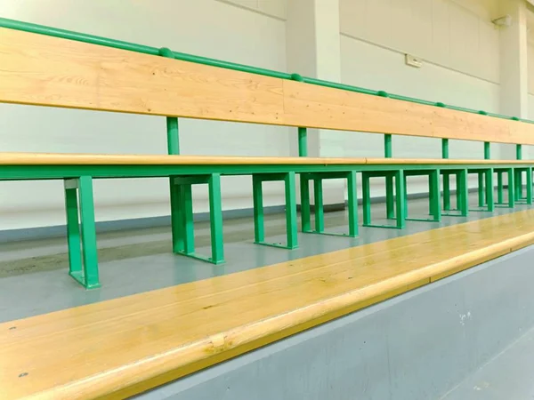 Lege houten stoelen in een sportstadion. Tribune voor fans van wedstrijden met bankjes. — Stockfoto