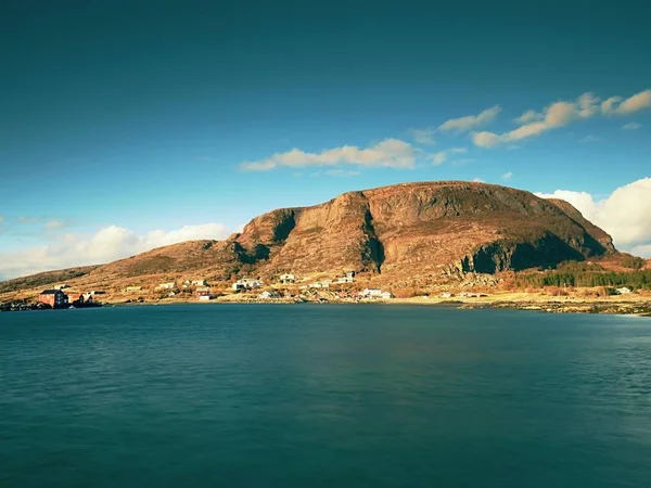 Pequeño pueblo pesquero en la isla rocosa en el océano Norte. casas tradicionales rojas y blancas de madera cerca del puerto —  Fotos de Stock