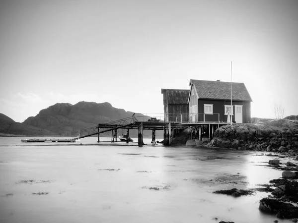 Traditional red and white houses in small fishing village. Silent bay in spring Norway