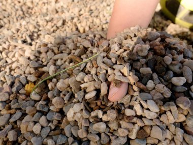 Çocuk el kumlu yüzey altında gizli. Ayrıntı görünümü küçük taşlar oyun alanında yer.