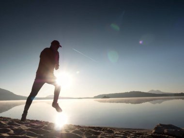 Adam güneş gözlüğü, Kırmızı beysbol şapkası ve siyah spor giyim çalışan ve kumsalda egzersiz kırmızı.