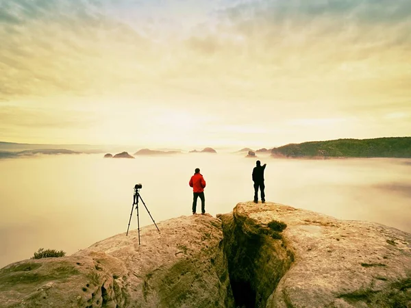 Dva fotografové teplý kabát s stativu fotografovat podzimní krajiny pod horou. — Stock fotografie