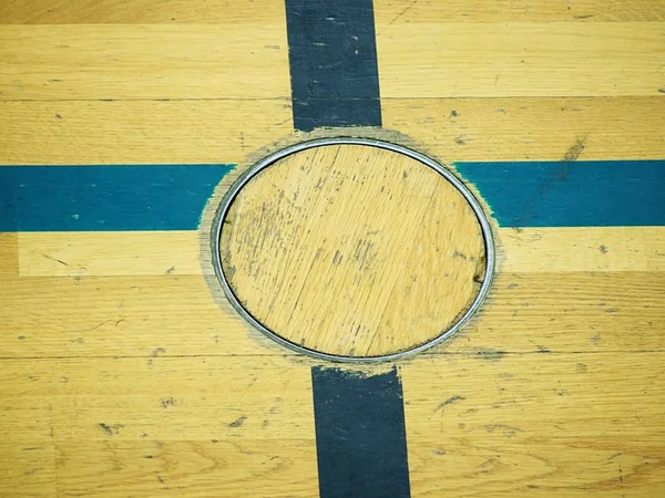 Bodendeckel für Trainingsgeräte, Detail im Boden der Schulsporthalle. schwarz bemaltes Kreuz — Stockfoto