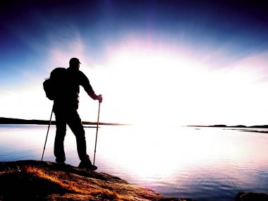 Sahil güzel yaz günbatımında. Adam karşı günbatımı okyanus, sırt çantası ile ayakta. 