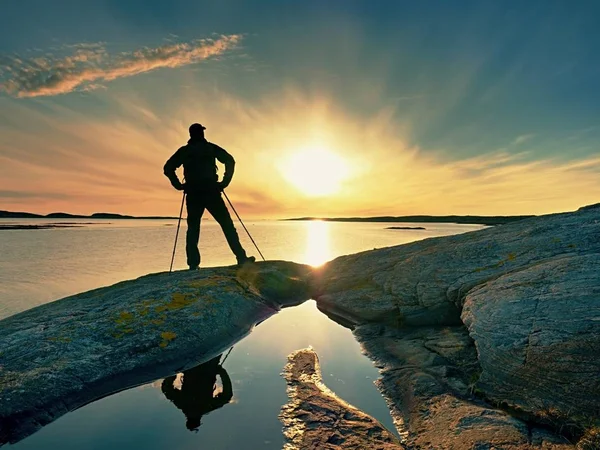 Όμορφο καλοκαιρινό ηλιοβασίλεμα στην παραθαλάσσια. Στέκεται ο άνθρωπος με το σακίδιο στο ωκεανό κατά το ηλιοβασίλεμα. — Φωτογραφία Αρχείου