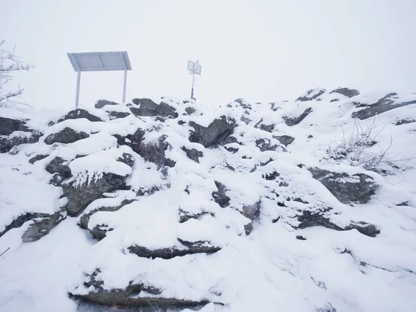Taze kar kar, ağır siste gizlenmiş manzara ile kayalık arazi yakın çekim. — Stok fotoğraf