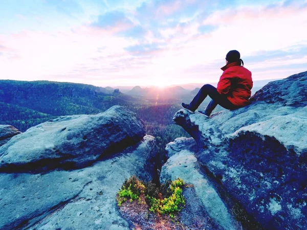 Foto filtrata blu. Un uomo con la giacca rossa che pensa a Rock Cliff. Serata malinconica nella natura . — Foto Stock