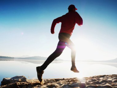 Adam güneş gözlüğü, Kırmızı beysbol şapkası ve siyah spor giyim çalışan ve kumsalda egzersiz kırmızı.