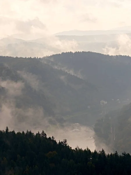 Ranní mlha a mlha pokrývá krajinu pod vrcholky hor — Stock fotografie
