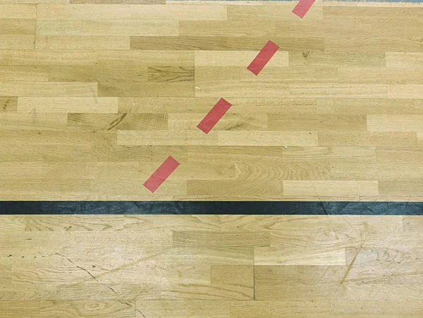 Ξύλινο πάτωμα στην αθλητική αίθουσα με στερεά και διακεκομμένες γραμμές. Ανάκλαση του φωτός — Φωτογραφία Αρχείου