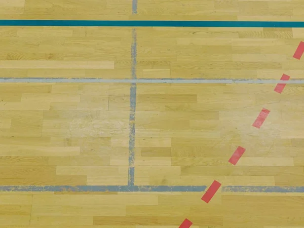 Оновлення дерев'яної підлоги спортивного залу з барвистими лініями розмітки та новою лакованою поверхнею . — стокове фото