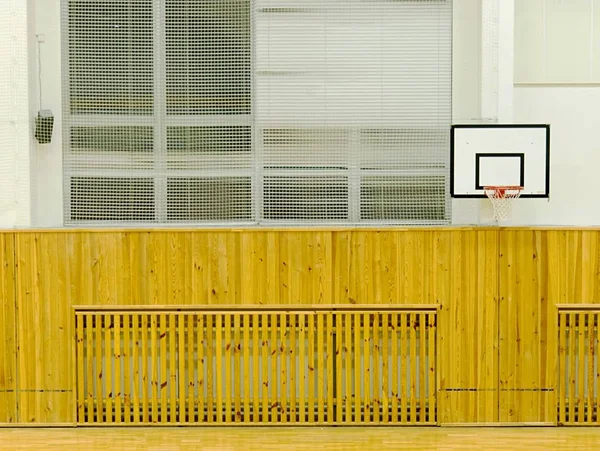 Interiören i skola gym med väggar täckta av skyddsnät. Stor hall med basket styrelse — Stockfoto