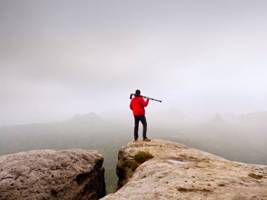 Turist görünümünde kırmızı kış ceket üzerine gelin. Milli park. Yağmurlu Eylül sabah.