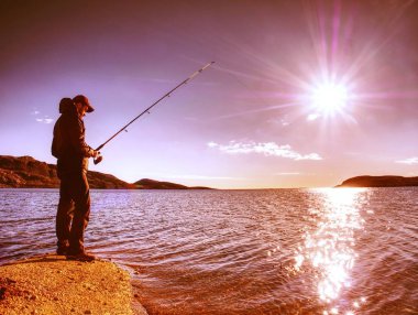 Balıkçı siluet satır balıkçılık ve yem çubuk üzerinde iterek günbatımı balıkçı Check