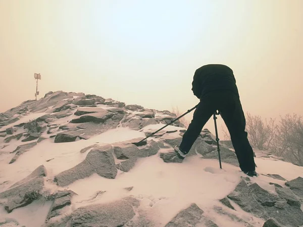 Reisefotograf beim Fotografieren in uralten Steinen auf schneebedeckten Gipfeln des Berges. Wintermorgen — Stockfoto