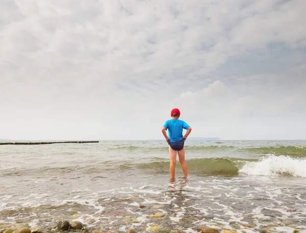 Los niños en la playa van al océano. Niño jugar en las olas —  Fotos de Stock