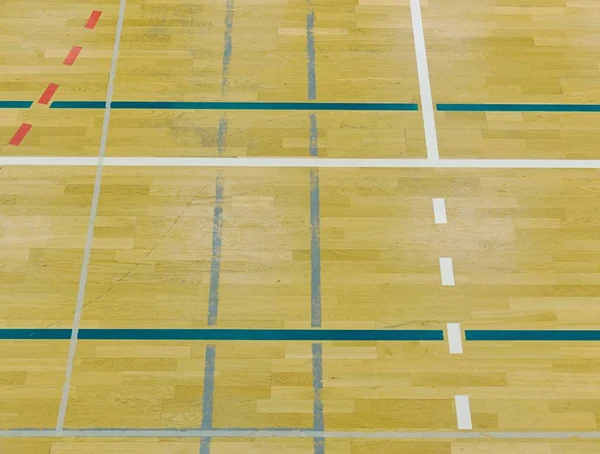 Piso de madeira em salão desportivo com linhas sólidas e pontilhadas. Reflexão da luz — Fotografia de Stock