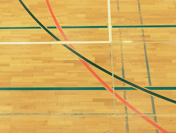 Lignes pleines ou pointillées noires, blanches et rouges dans l'aire de jeux du hall. Sol en bois usé — Photo