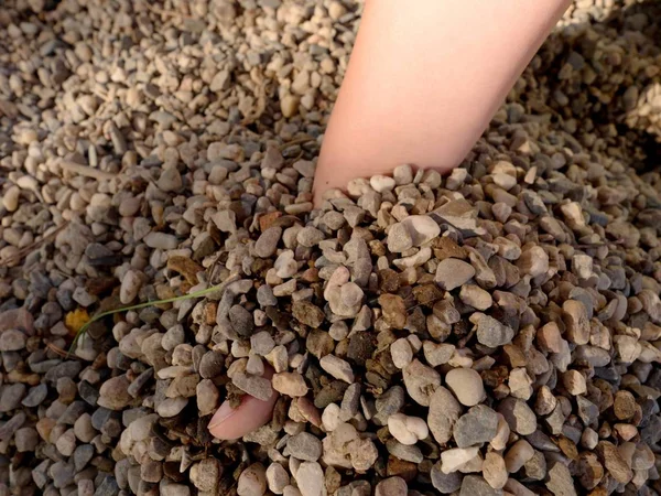 Παιδί χέρι οικοδομήσει οχυρό στην άμμο ή πετραδάκια πυλώνα, σπασμένα κλαδιά και φύλλα — Φωτογραφία Αρχείου