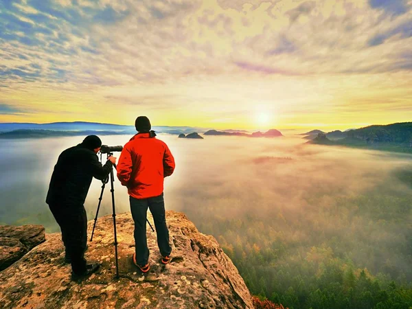 Photographying in wild nature. Nature photographer with big camera on tripod stay on summit rock. Listen to muse — Stock Photo, Image