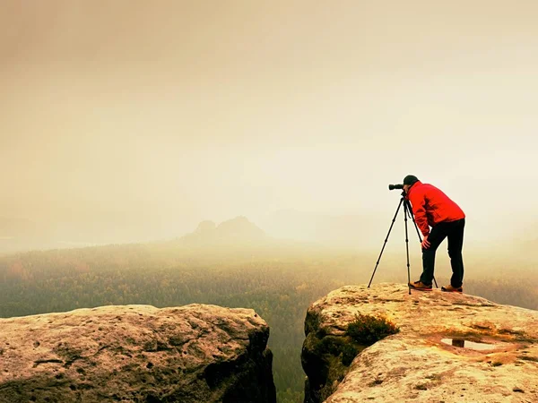 Professionelle Fotografen arbeiten auf dem Gipfel des Berges. Naturfotograf fotografiert mit Spiegelkamera auf Felsen — Stockfoto