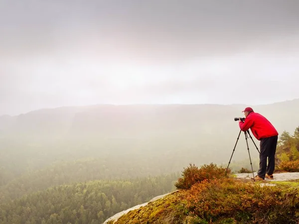 Artist stay  with tripod on summit and  takes pictures of autumnal coutryside. Misty landscape — Stock Photo, Image
