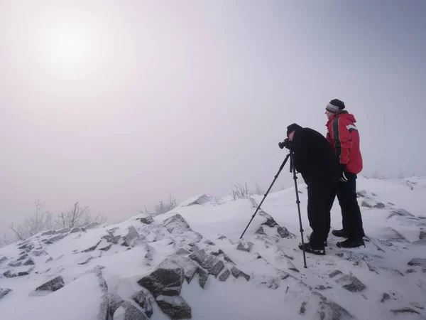 Twee mannen genieten van winter photographying in besneeuwde bergen. Natuurfotograaf — Stockfoto