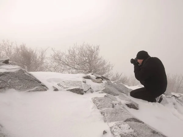 El hombre toma la foto del amanecer otoñal congelado, rocas con nieve en polvo . — Foto de Stock