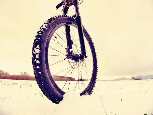 Invierno mtb montar en el país nevado. Vista baja del tobillo a la rueda con neumático de lodo de nieve . — Foto de Stock