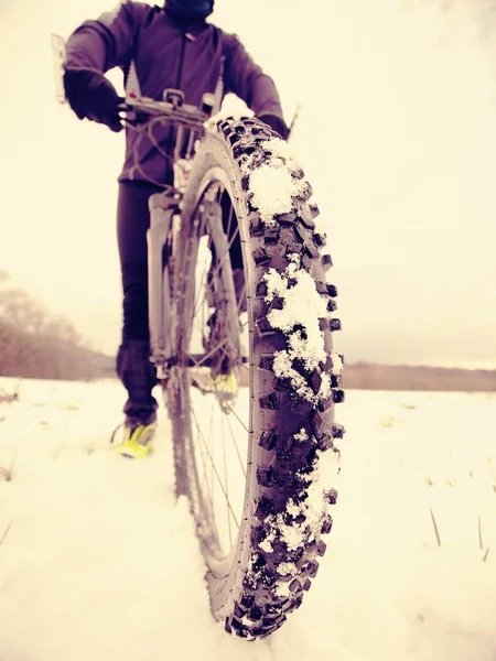 Homem ciclista com bicicleta de inverno fica na neve. Inverno conceito esportivo extremo . — Fotografia de Stock
